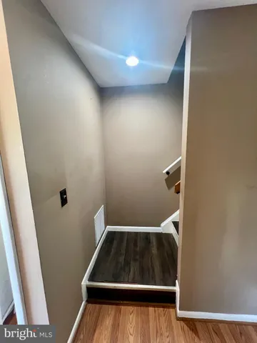 a kitchen with granite countertop wooden floors and white stainless steel appliances