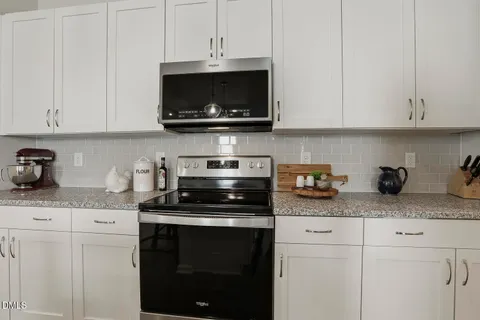 a kitchen with kitchen island granite countertop a table chairs sink and microwave