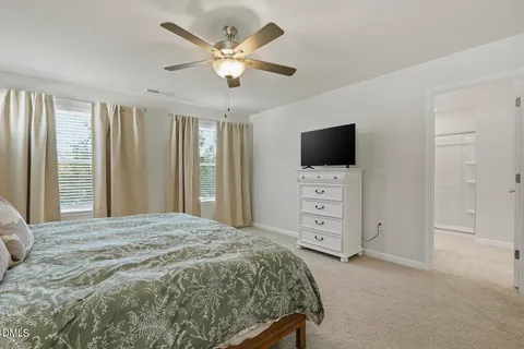 a bedroom with a large bed and a ceiling fan