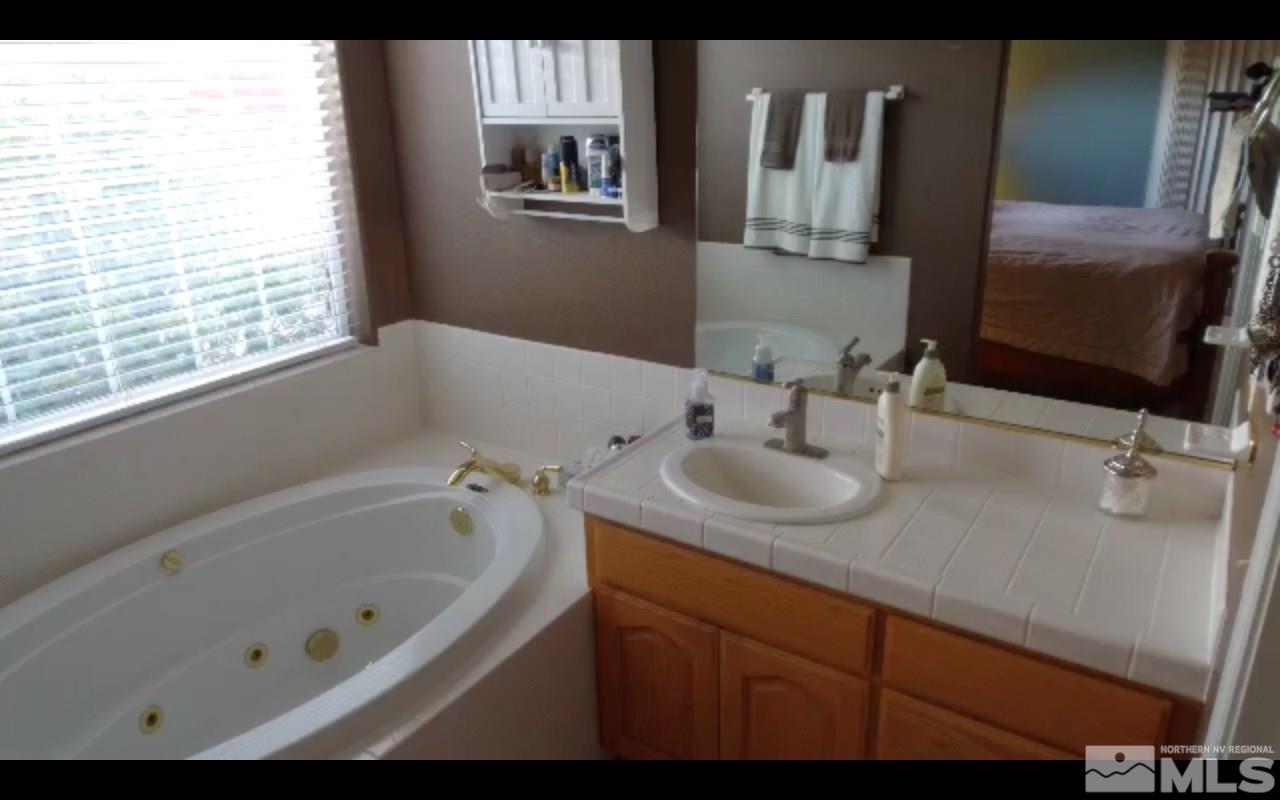 5141 Solias Road Fallon, NV 89406 - Photo 12 of 24 a bathroom with a tub sink and mirror