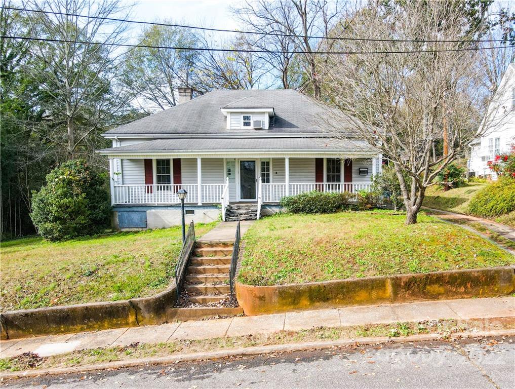 199 North Meridian Street Rutherfordton, NC 28139 - Photo 3 of 39 a view of a white house with a small yard plants and large tree