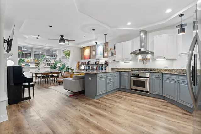 a kitchen with stainless steel appliances kitchen island granite countertop a stove top oven a sink a dining table and chairs