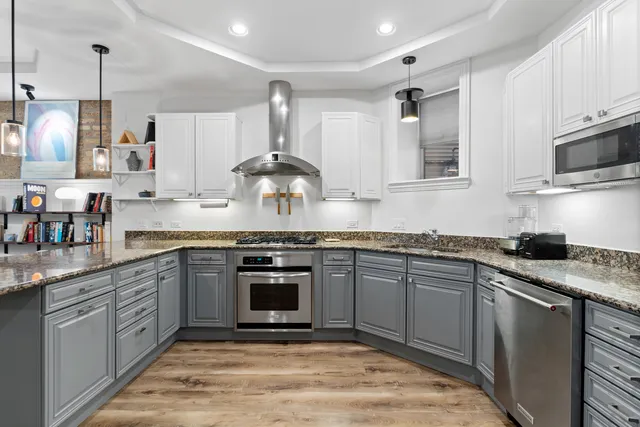 a kitchen with stainless steel appliances granite countertop a sink stove and cabinets