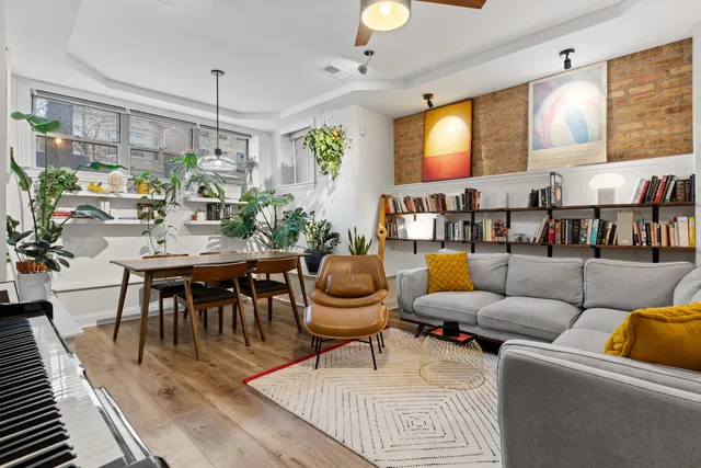 a living room with furniture a chandelier and a table