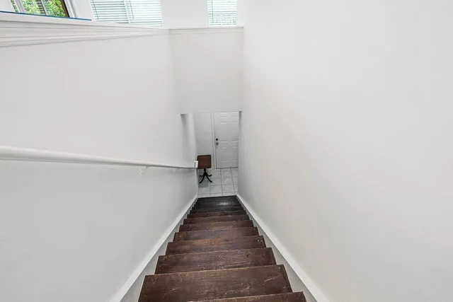 a view of a hallway with wooden floor and staircase