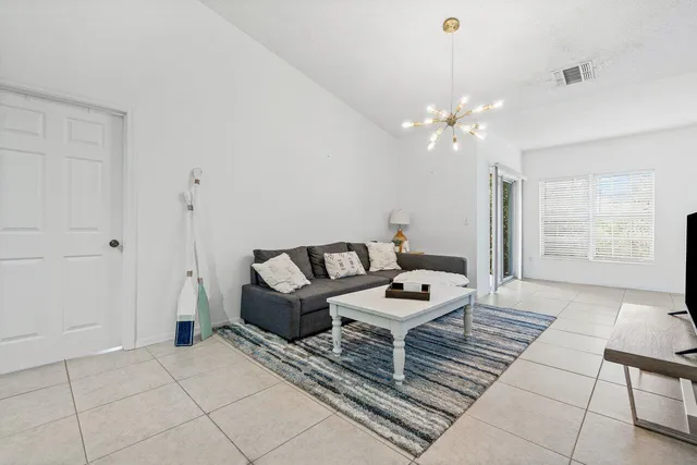 a living room with furniture a chandelier and a window