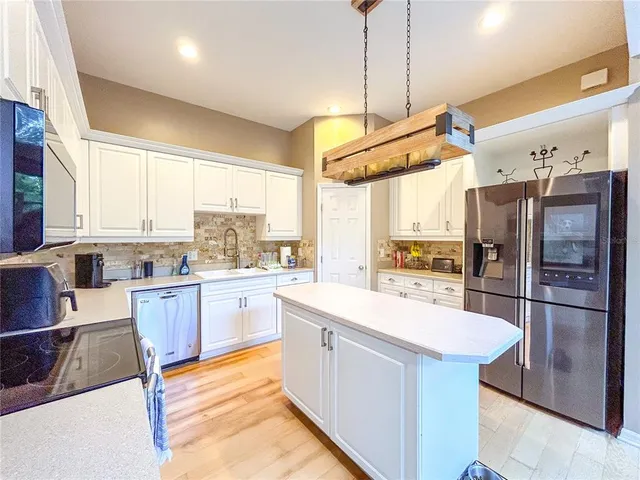 a kitchen with a refrigerator a sink and cabinets