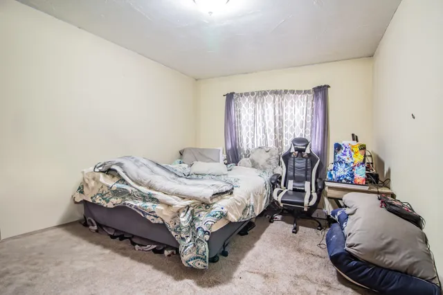 a bed sitting in a bedroom next to a window