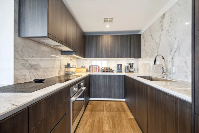 a kitchen with kitchen island granite countertop wooden cabinets a sink and dishwasher