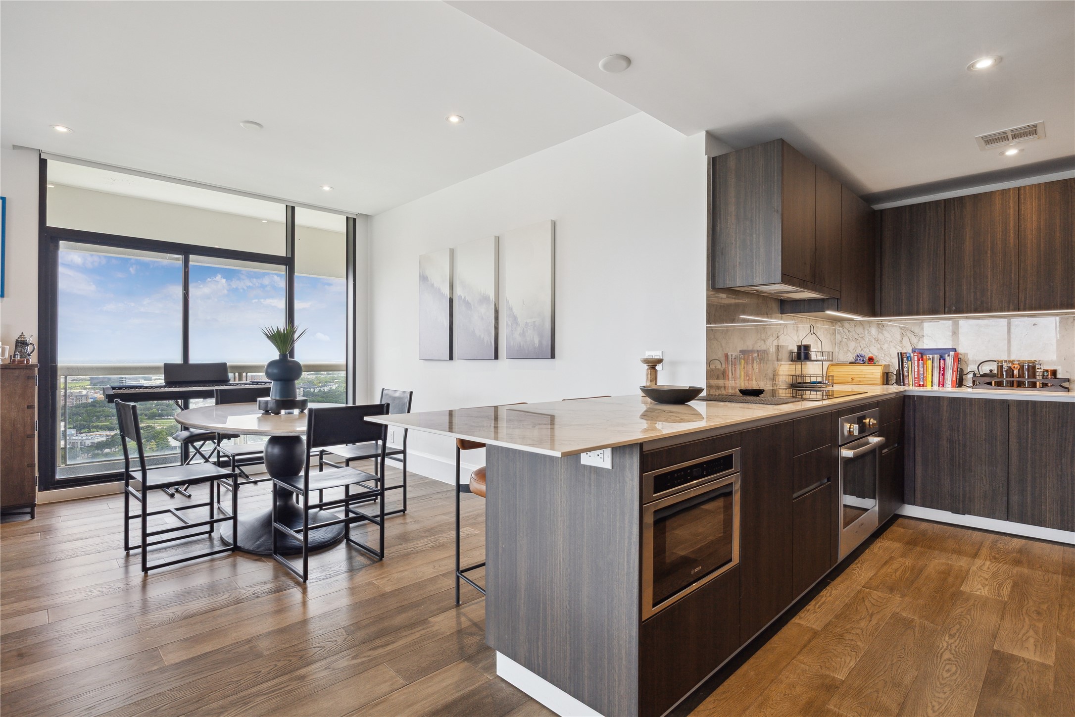 1701 Hermann Drive, Unit 23B Houston, TX 77004 - Photo 7 of 24 a kitchen with stainless steel appliances a table chairs sink and cabinets