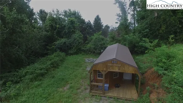 a aerial view of a wooden chairs and table in the backyard