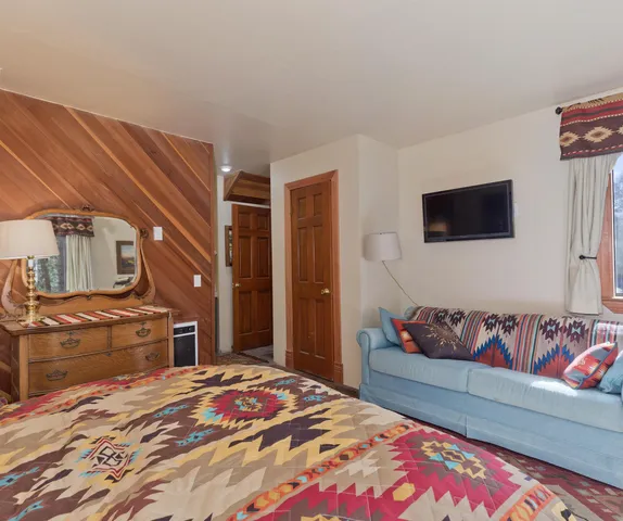 a bedroom with a bed and flat screen tv