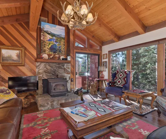 a living room with furniture a fireplace and large windows