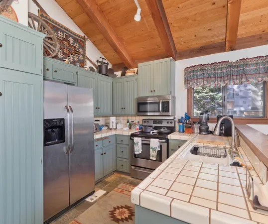 a kitchen with stainless steel appliances a sink a stove top oven a counter space and cabinets