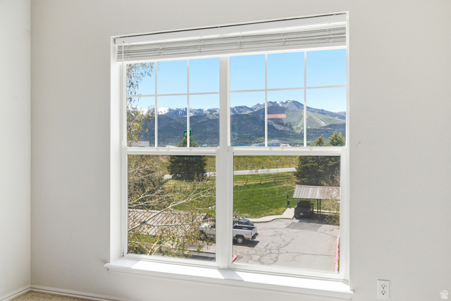 900 Bitner Road, Unit P20 Park City, UT 84098 - Photo 24 of 42 Large window with white frame and grids, offering a broad scenic backdrop of snow-capped mountains and green hills