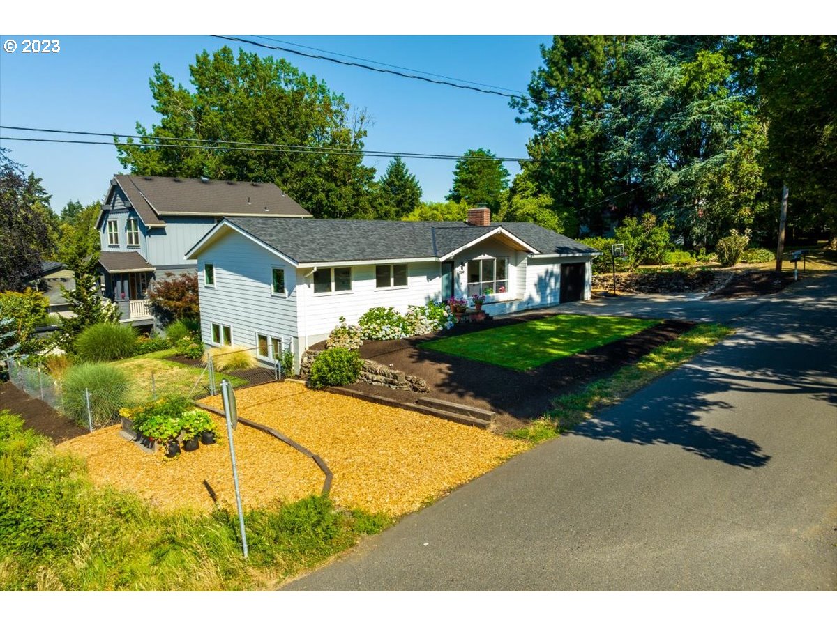7519 Southwest 53rd Avenue Portland, OR 97219 - Photo 28 of 30 a view of house with garden and tall trees