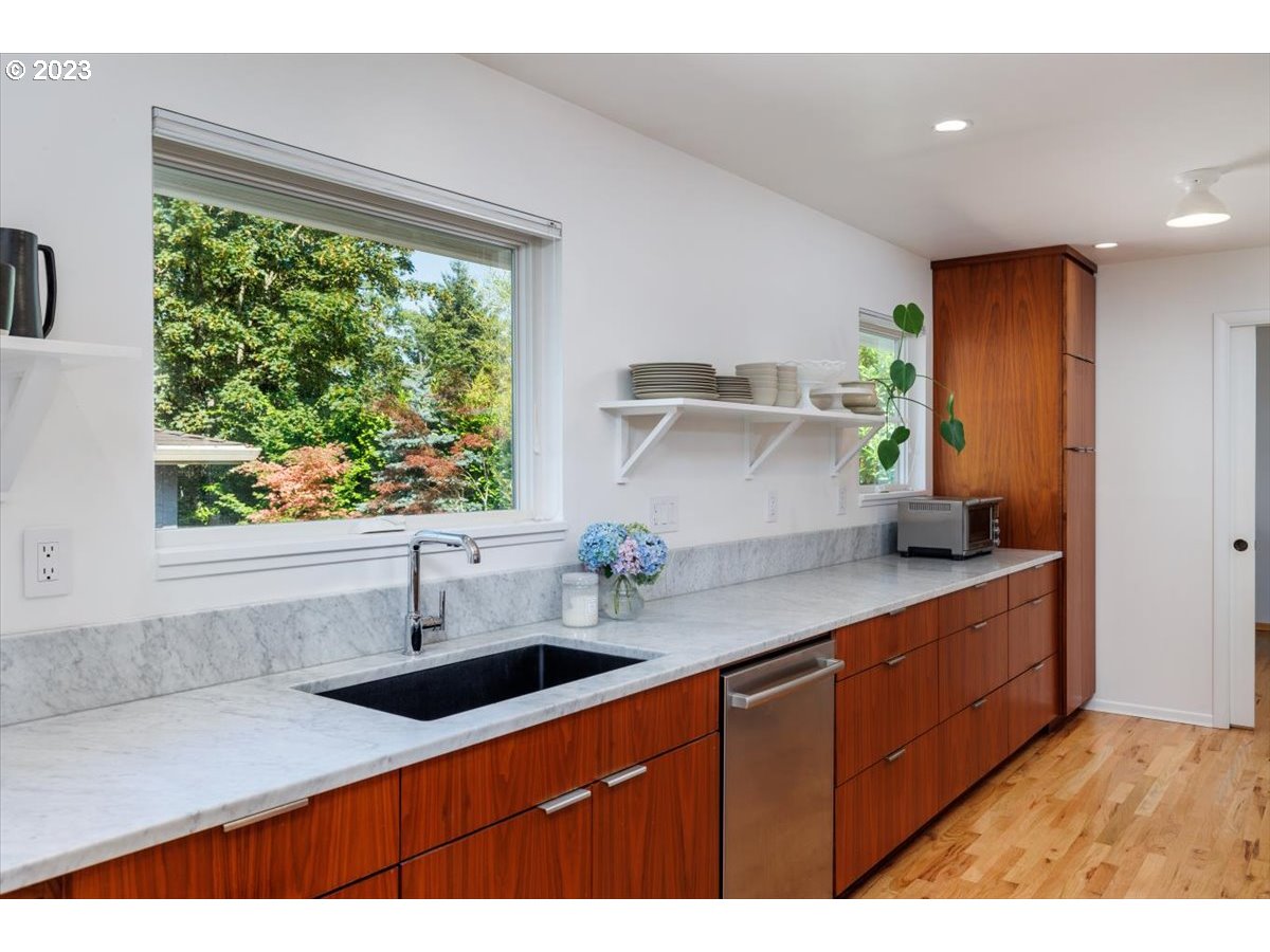 7519 Southwest 53rd Avenue Portland, OR 97219 - Photo 8 of 30 a kitchen with stainless steel appliances a sink a stove and a window