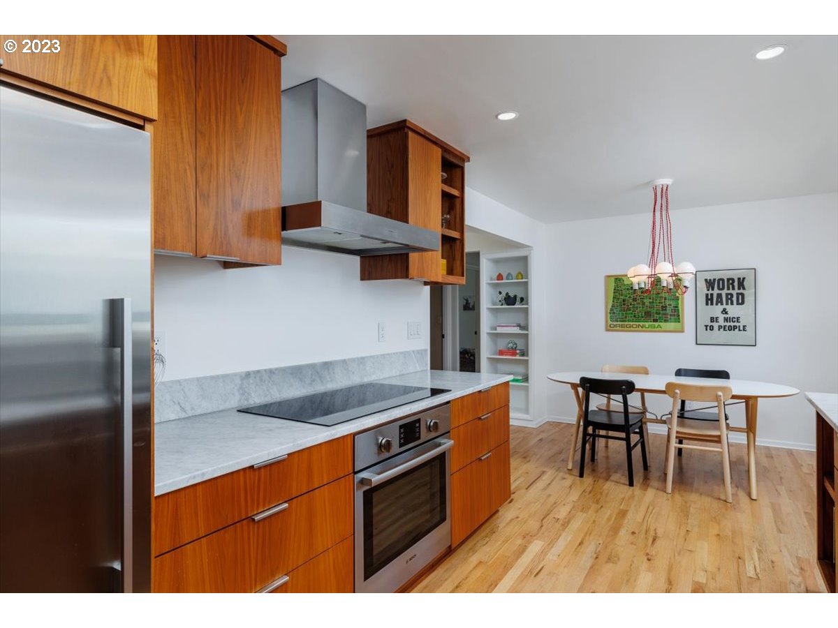 7519 Southwest 53rd Avenue Portland, OR 97219 - Photo 10 of 30 a kitchen with stainless steel appliances granite countertop a table chairs and a refrigerator