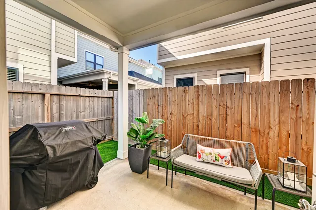 a living room with furniture a rug and kitchen view