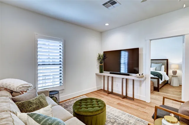 a bedroom with a bed a chair and a potted plant