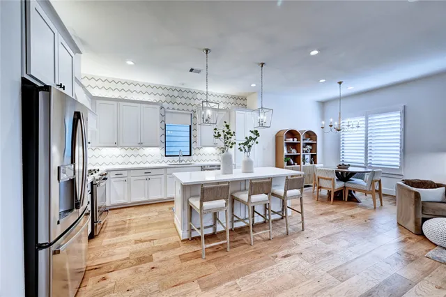a kitchen with a table chairs sink and cabinets