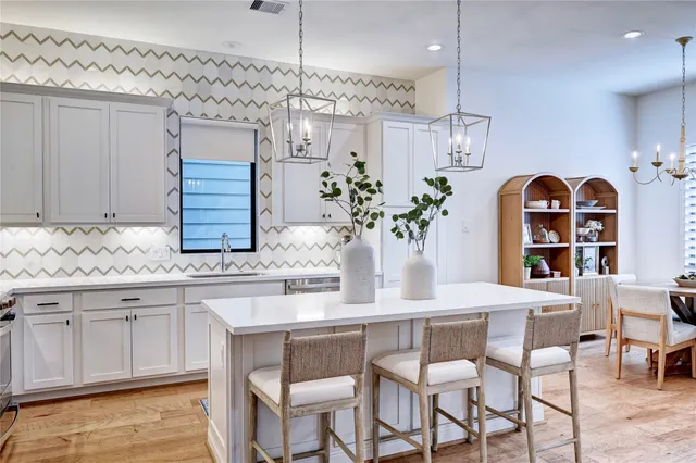 a large kitchen with kitchen island a large counter top space a sink stainless steel appliances and cabinets