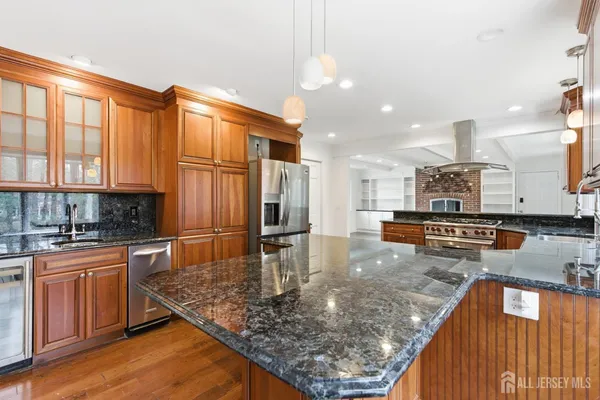 a kitchen with stainless steel appliances granite countertop a stove top oven a sink counter space and cabinets