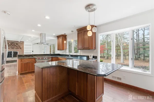 a kitchen with stainless steel appliances granite countertop a sink a stove and a counter top space