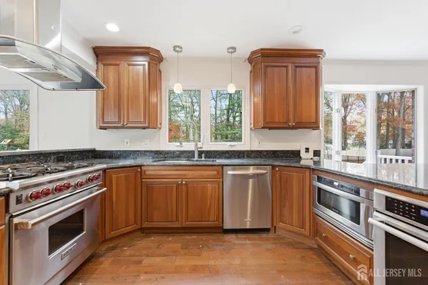 a kitchen with stainless steel appliances granite countertop a stove sink and cabinets