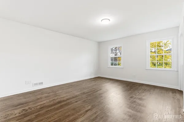 a view of an empty room with wooden floor