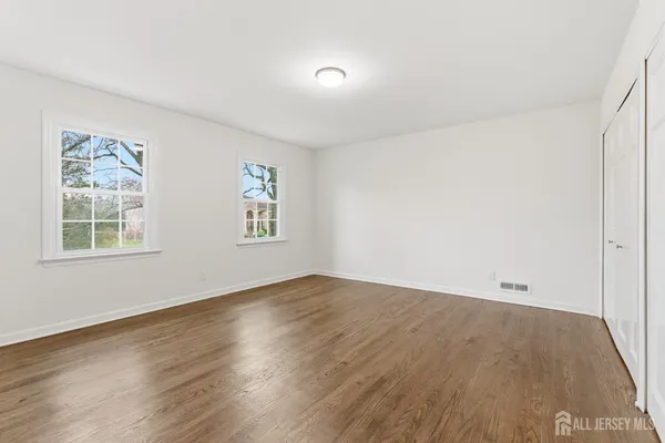 a view of an empty room with wooden floor