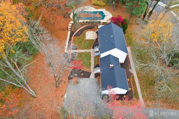 an aerial view of a house with a yard and large tree