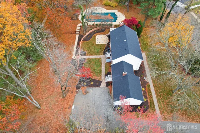 an aerial view of a house with a yard and large tree