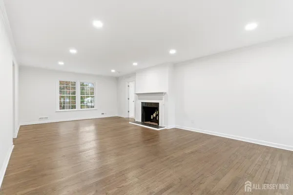 an empty room with wooden floor and fireplace