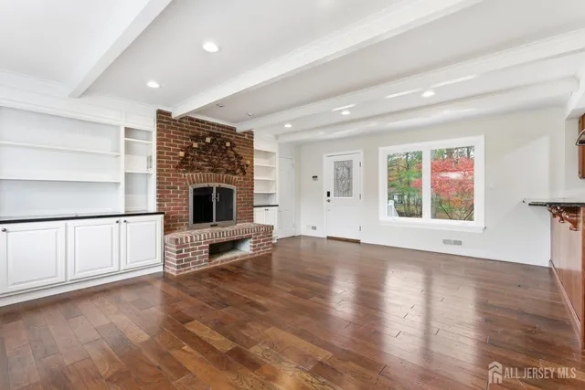 an empty room with fireplace wooden floor and windows