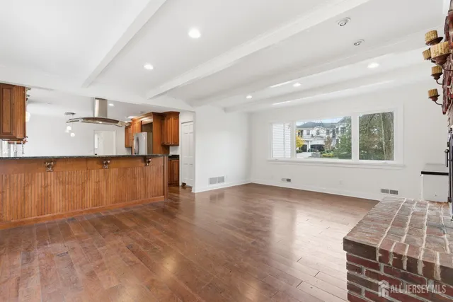 a view of a livingroom with wooden floor and furniture
