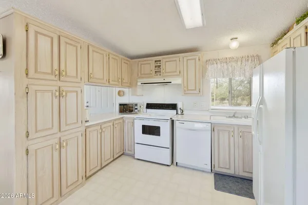 a kitchen with white cabinets and white appliances
