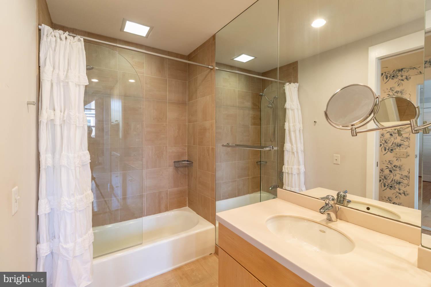 317-319 Vine Street, Unit 308 Philadelphia, PA 19106 - Photo 13 of 17 a bathroom with a sink mirror shower and a bathtub