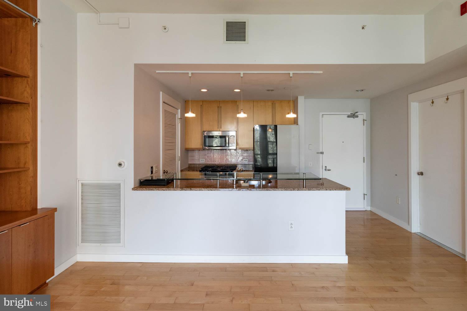 317-319 Vine Street, Unit 308 Philadelphia, PA 19106 - Photo 6 of 17 a large white kitchen with kitchen island a sink a stove and a refrigerator