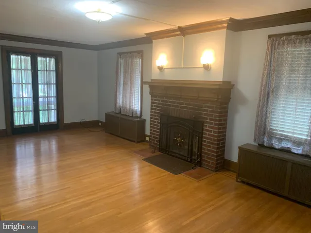 an empty room with wooden floor and fireplace