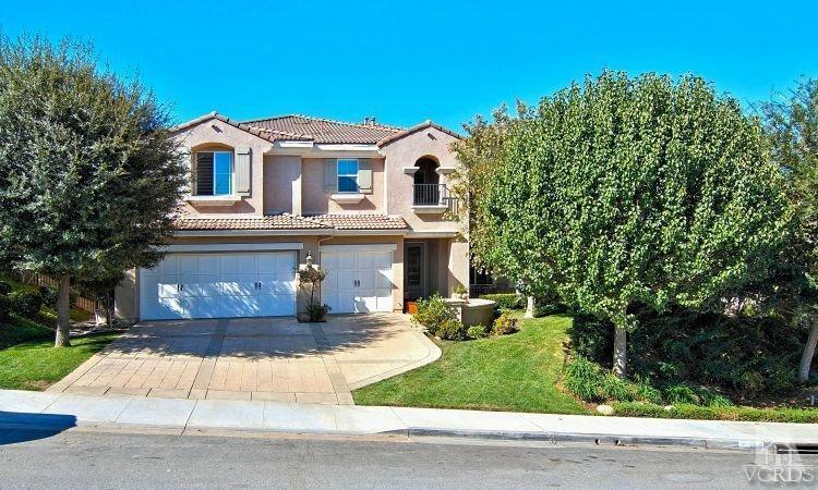 1373 Hidden Ranch Drive Simi Valley, CA 93063 - Photo 2 of 50 a view of a white house with a large windows and a yard with plants and large trees