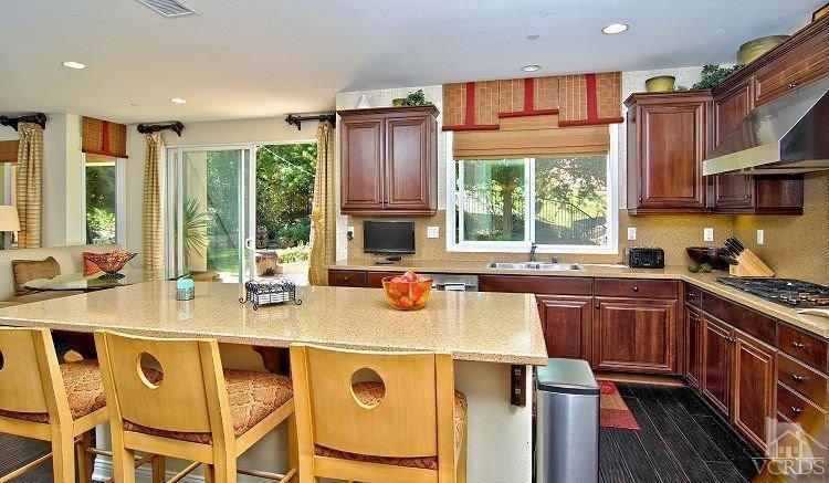 1373 Hidden Ranch Drive Simi Valley, CA 93063 - Photo 22 of 50 a kitchen with a stove a sink a refrigerator and wooden cabinets