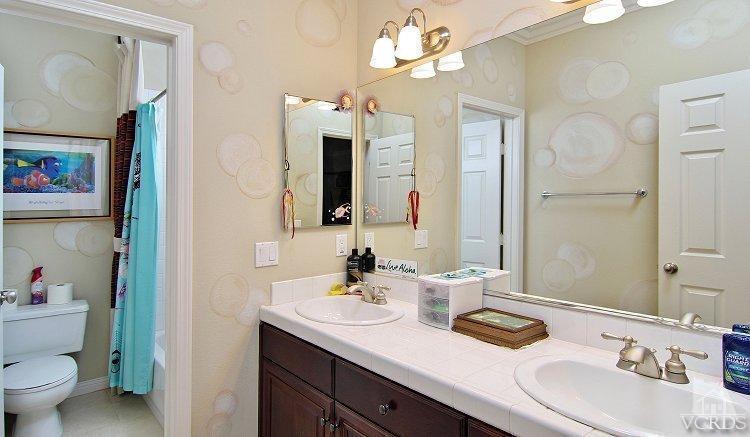 1373 Hidden Ranch Drive Simi Valley, CA 93063 - Photo 45 of 50 a bathroom with a granite countertop sink a toilet and a mirror