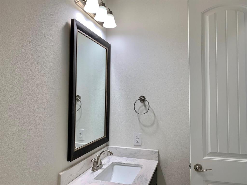 822 Susan Street Anna, TX 75409 - Photo 16 of 20 a bathroom with a mirror and a sink