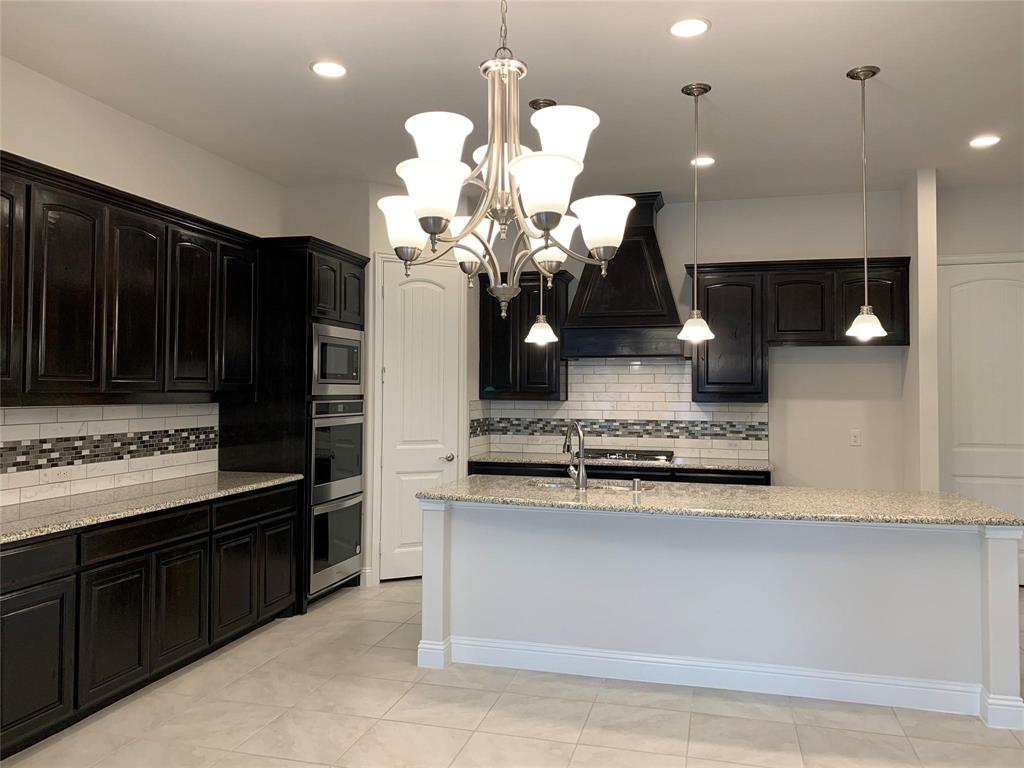 822 Susan Street Anna, TX 75409 - Photo 8 of 20 a kitchen with stainless steel appliances granite countertop a sink a stove and a wooden floors