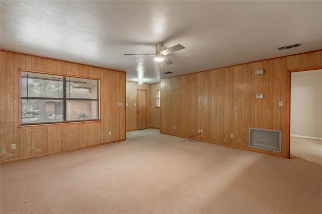 an empty room with closet and fan