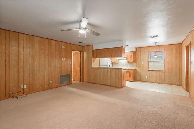 an empty room with closet and a ceiling fan