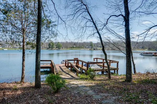 a view of a lake with a bench next to a yard