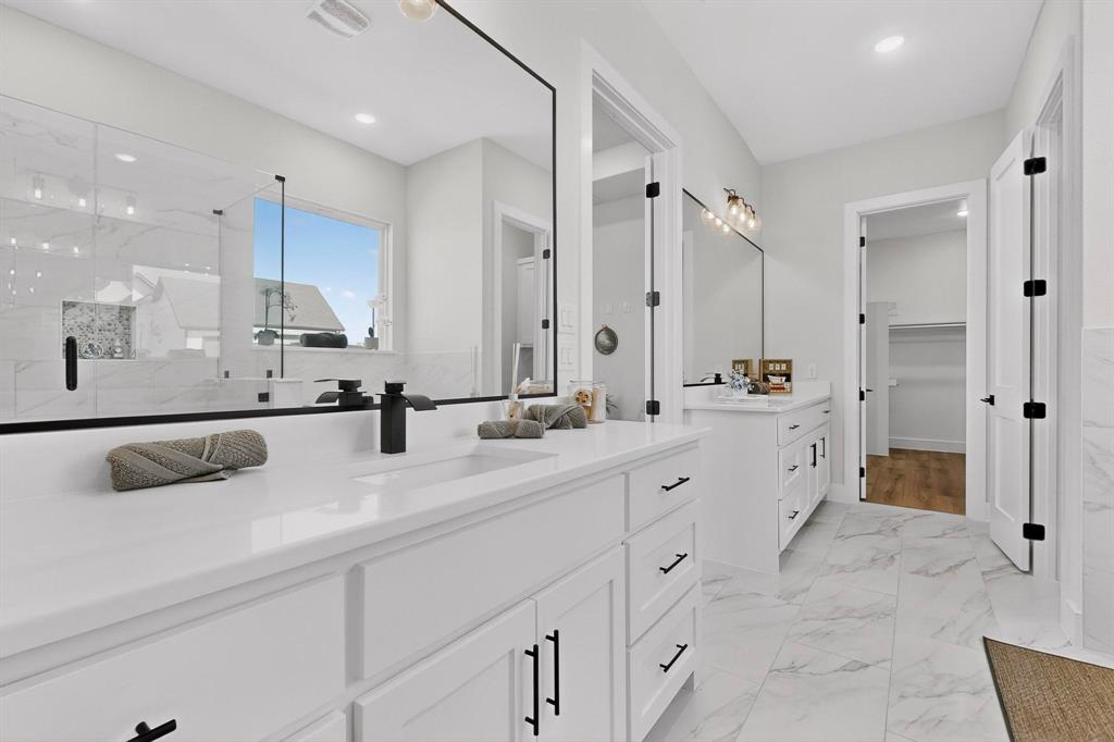 4961 County Road 1098 Celeste, TX 75423 - Photo 22 of 40 Full bath with two vanities, light marble finish flooring, a marble finish shower, a walk in closet, and recessed lighting