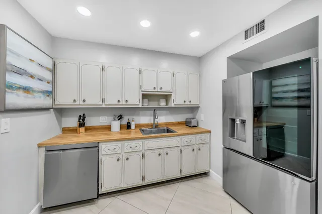 a kitchen with a sink dishwasher a refrigerator and cabinets